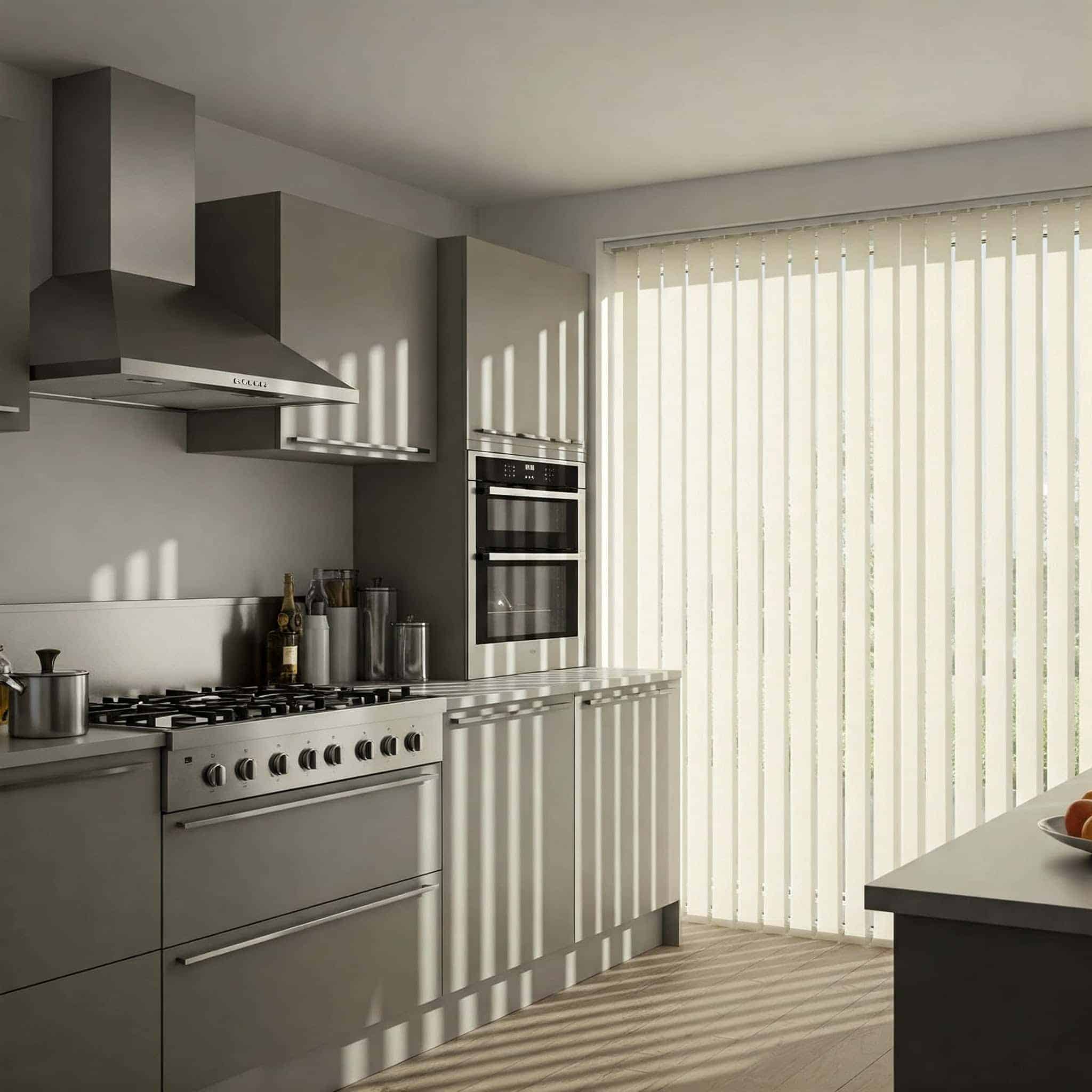 Modern kitchen with gray cabinets, a stainless steel stove and hood, built-in ovens, and vertical blinds letting sunlight create striped shadows across the room. Bottles and utensils rest on the countertop beneath stylish windows coverings.