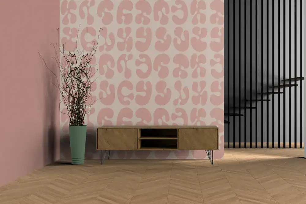 A minimalist room with a light wood herringbone floor, a low wooden console table, a large green vase with dried branches, a pink wall with abstract patterns, and black vertical railings by a staircase.