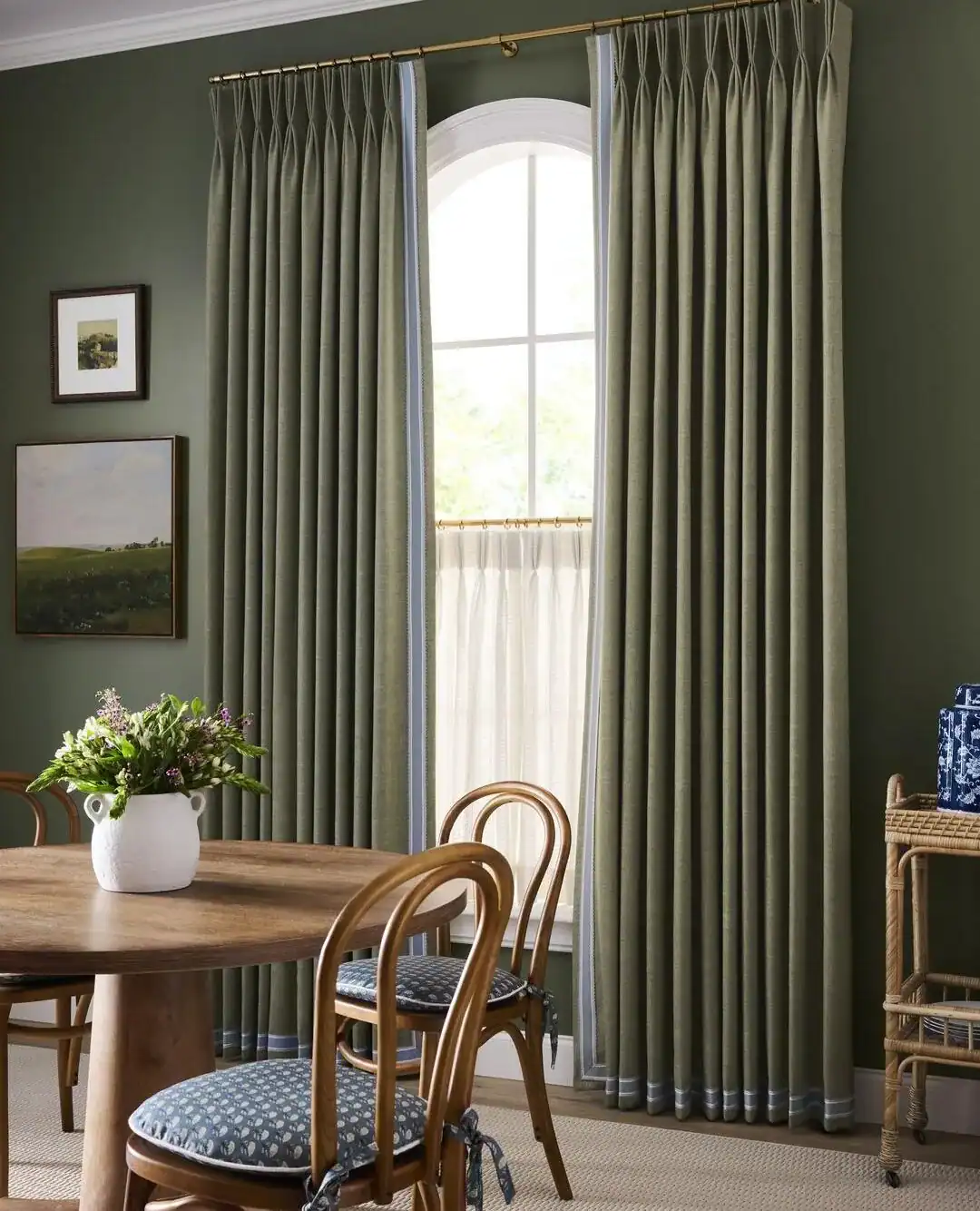 Dining room with elegant green curtains and wooden furniture.