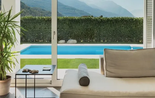 Modern living room overlooking a pool and hedge