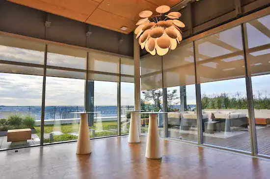 Spacious modern lounge with glass walls and sea view.