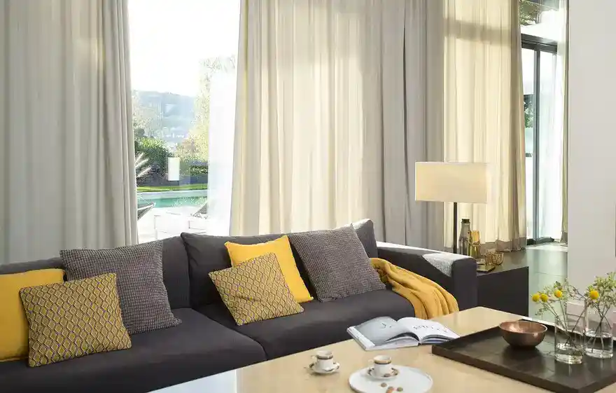 Contemporary living room with gray sofa, yellow pillows, and coffee table.