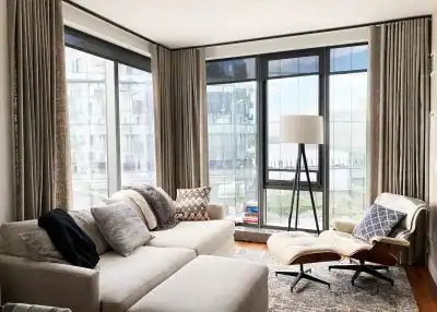 Modern living room featuring large windows and cozy furniture.