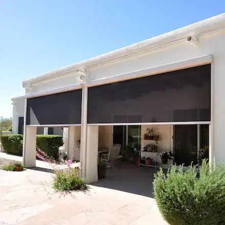 Patio with black roller shades providing shade in a sunny area.