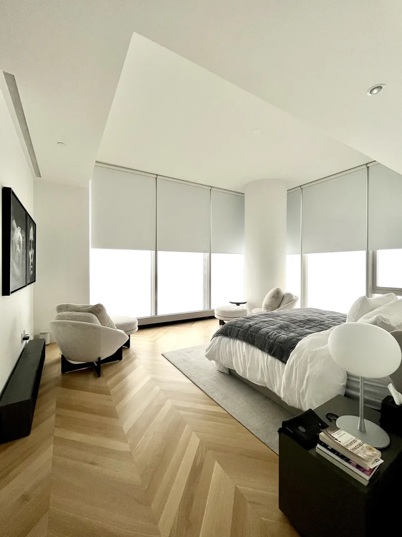 View from the entry across a bedroom toward adjacent window walls